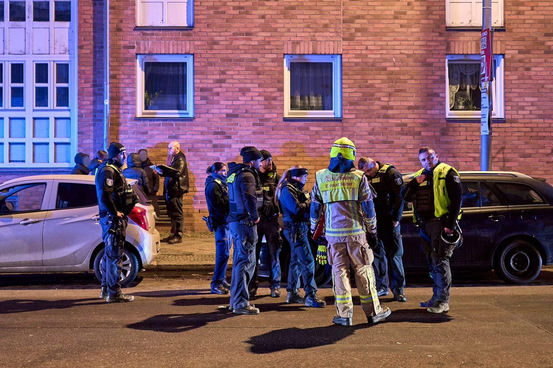 Polizisten stehen in der Nähe des Tatortes: In Kreuzberg ist ein junger Mann durch Schüsse aus einer Schreckschusspistole verletzt worden.