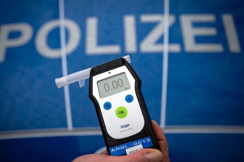 Ein Polizeibeamter hält während einer Verkehrskontrolle ein Messgerät Alcotest (Symbolbild).