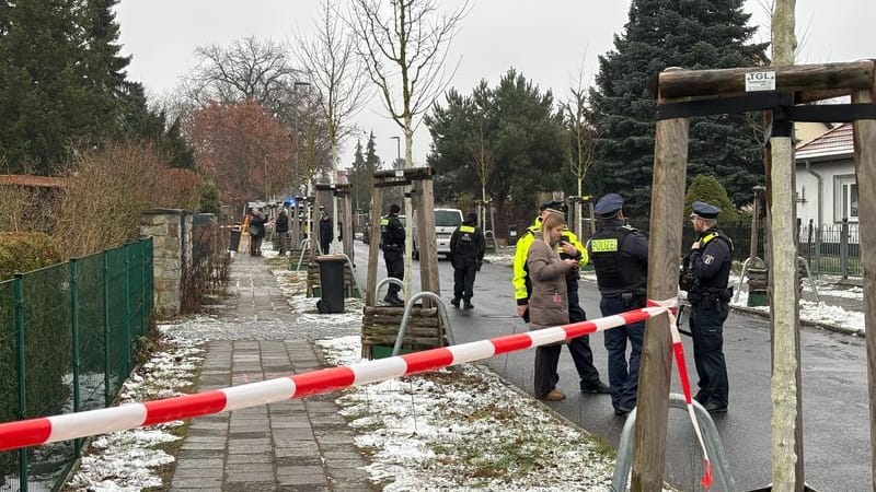 Einsatzkräfte stehen in einer Straße in Köpenick: Polizisten haben bei einem Einsatz in Berlin-Köpenick auf einen Mann geschossen und diesen verletzt.