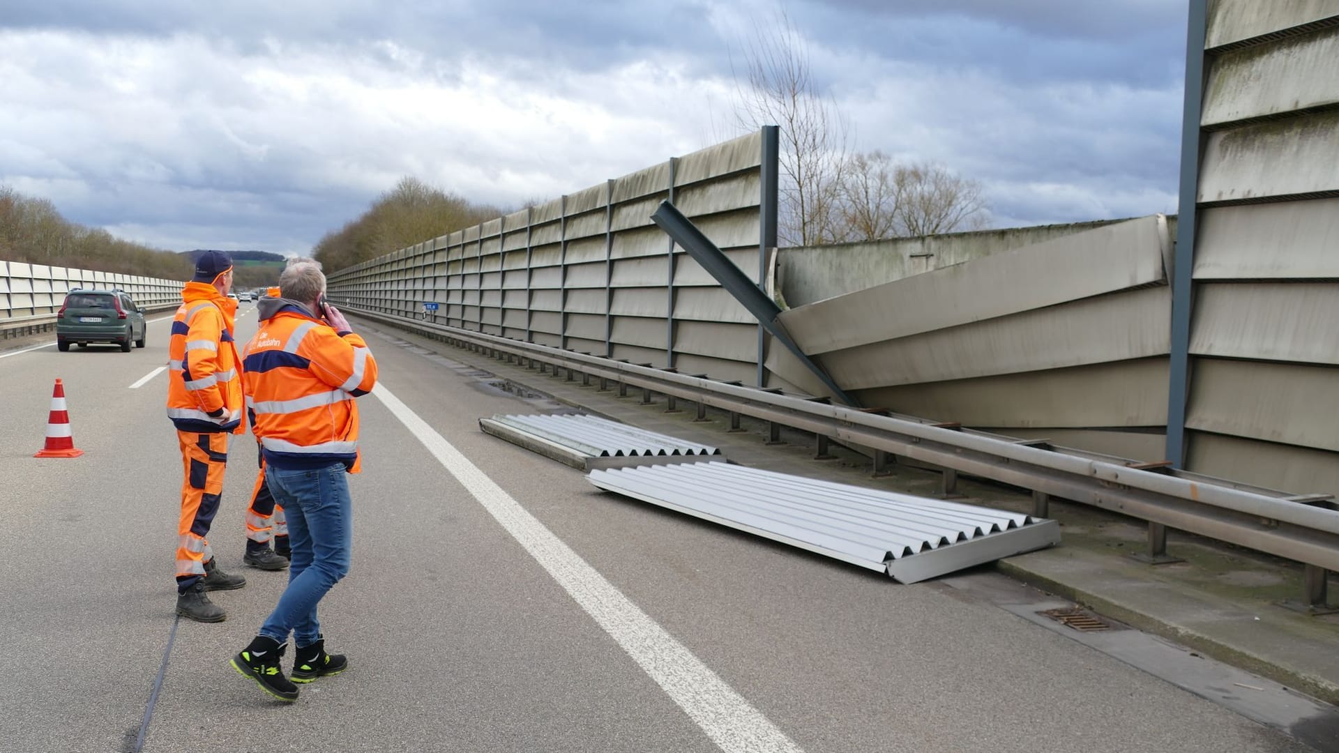 Arbeiter stehen vor den Teilen einer Lärmschutzwand auf der Autobahn 560 in Hennef.