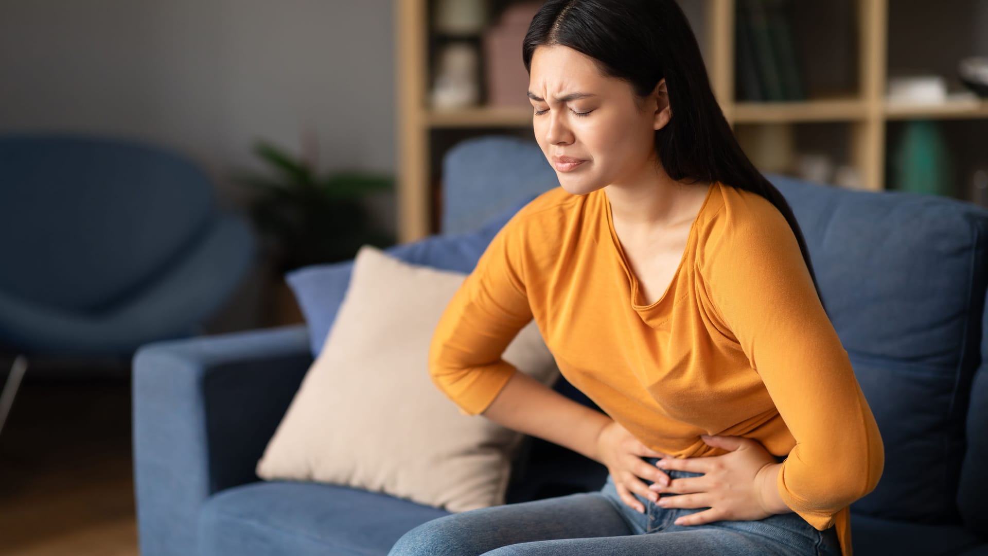 Eine Frau hält sich die Hände vor den Bauch.