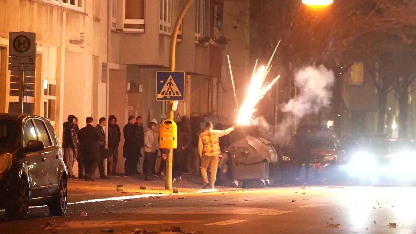 Männer zünden Feuerwerk in der Silbersteinstraße in der Silvesternacht.