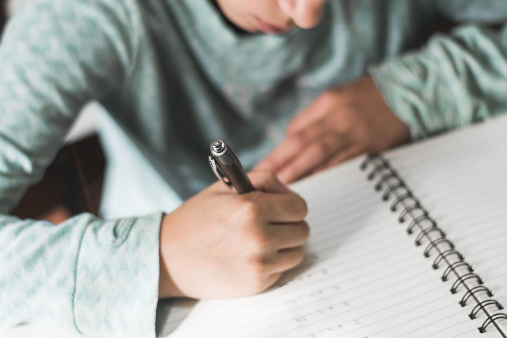 Ein Kind schreibt in einen Block: Schuleingangsuntersuchungen haben Defizite ans Licht gebracht.