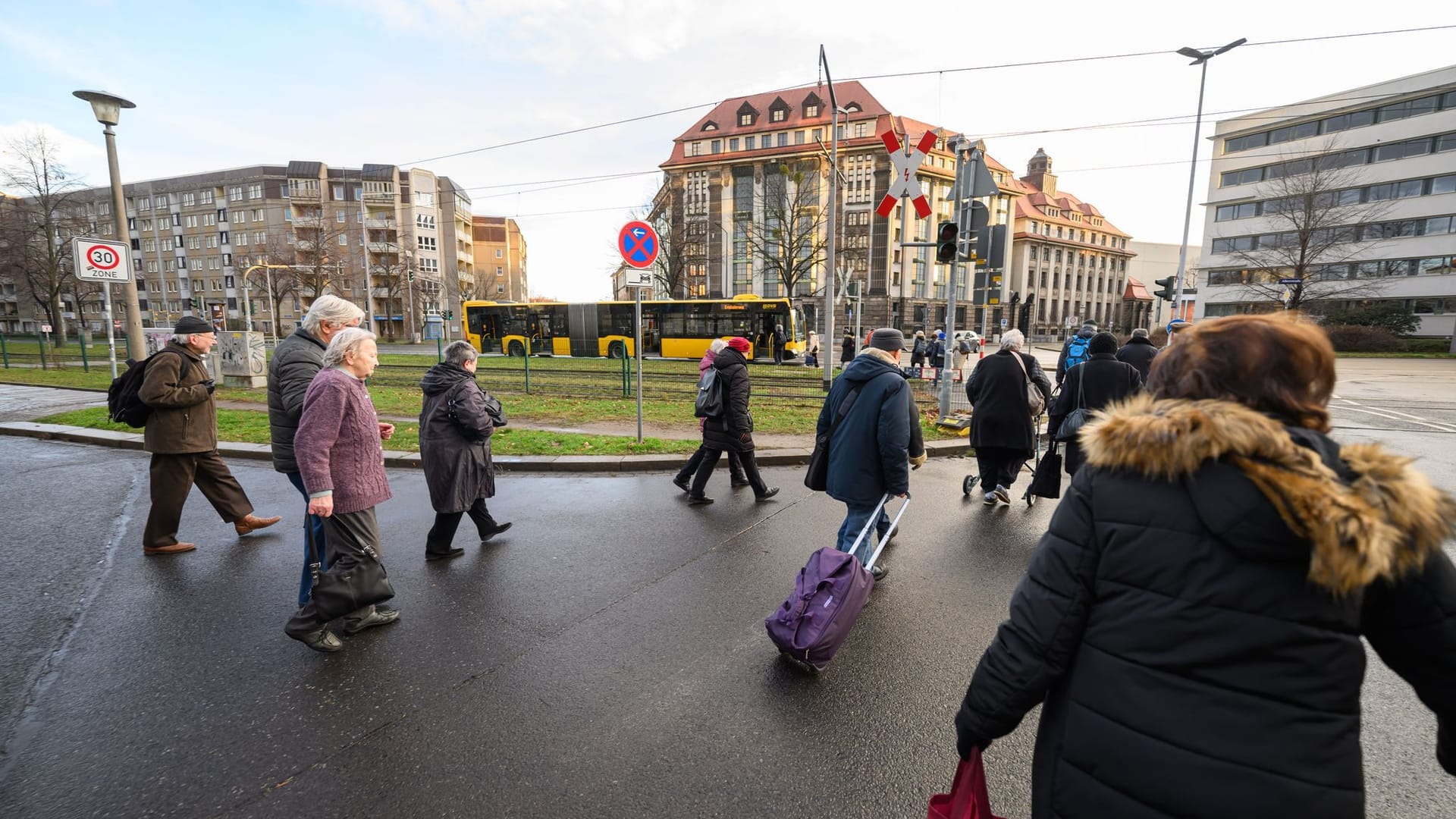 Bewohner gehen zu einem Bus, der für eine Evakuierung bereitsteht.