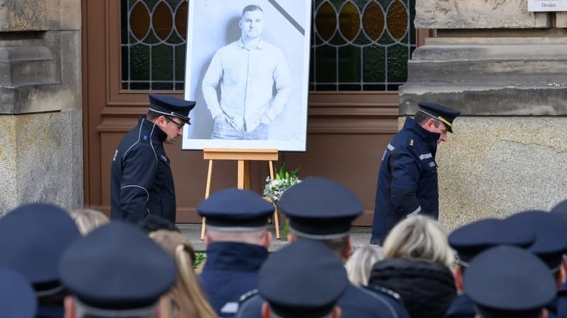 Polizisten stehen zum Gedenken des im Einsatz getöteten Kollegen Maximilian Stoppa für eine Schweigeminute vor dem Polizeipräsidium, an dem ein Porträtfoto des Kollegen aufgestellt ist. Der 32 Jahre alte Polizist wurde am 7. Januar 2024 in Lauchhammer im Grenzgebiet zu Sachsen bei einem Einsatz gegen mutmaßliche Autodiebe getötet.