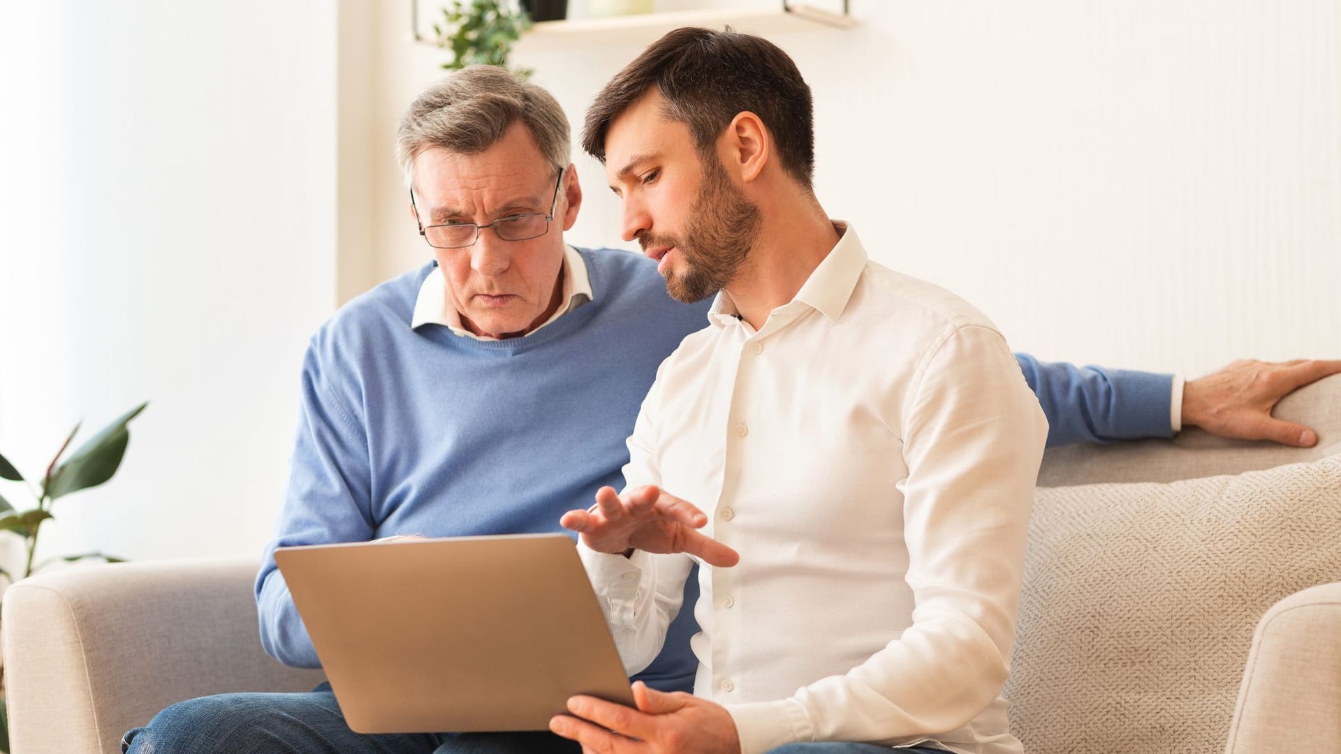 Vater und Sohn am Laptop: Um Probleme mit einem Gemeinschaftskonto zu vermeiden, sollten Sie die rechtlichen Vorgaben kennen.