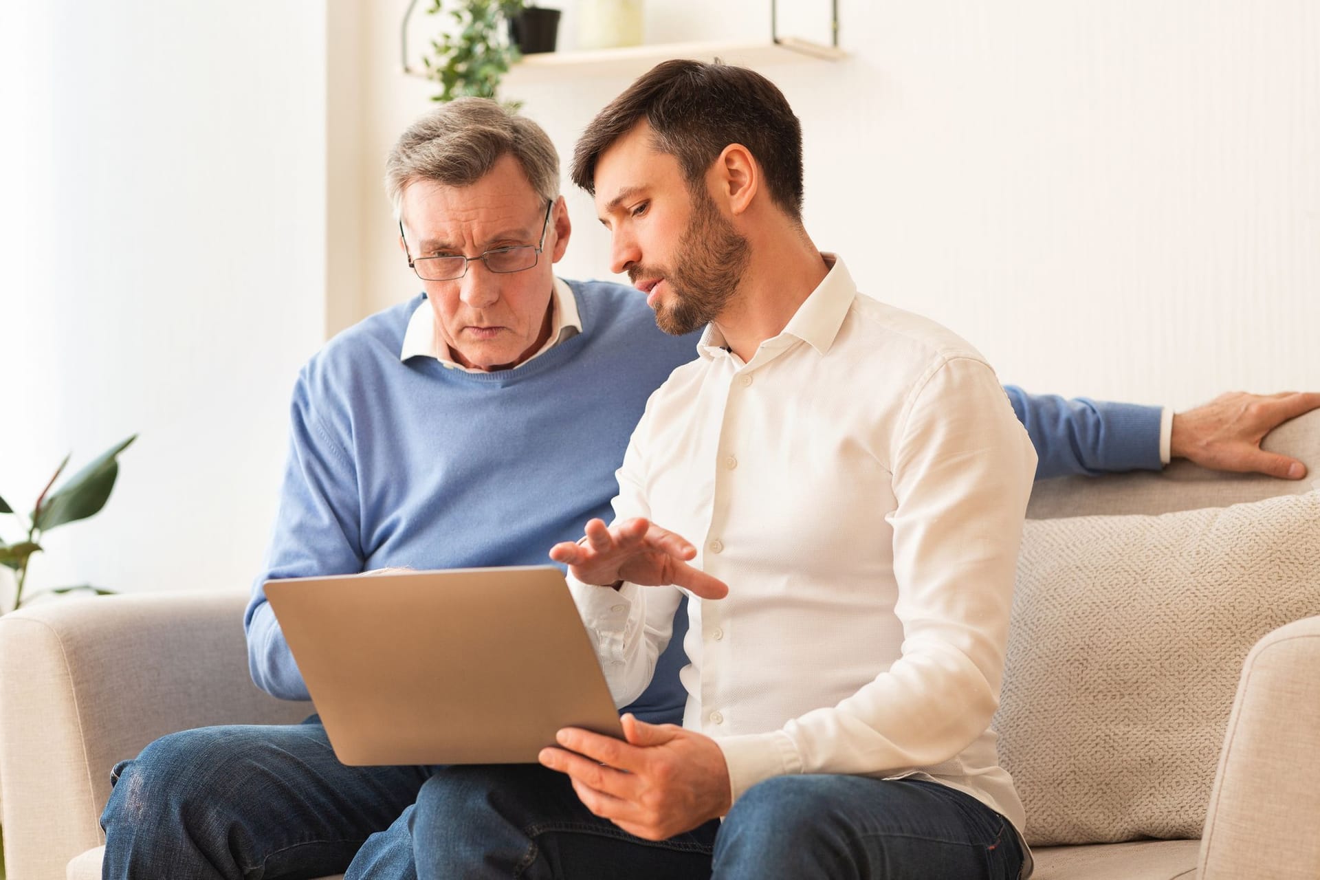 Vater und Sohn am Laptop: Um Probleme mit einem Gemeinschaftskonto zu vermeiden, sollten Sie die rechtlichen Vorgaben kennen.