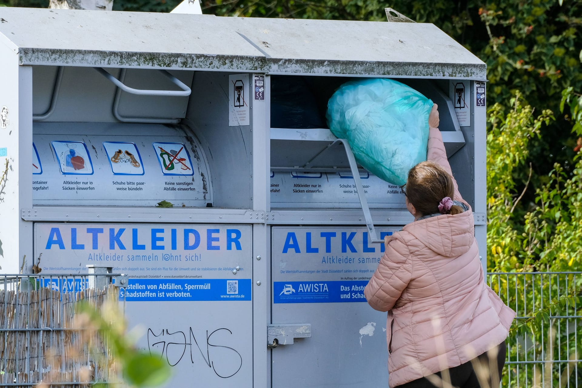 Person wirft Sack in Altkleidercontainer (Symbolbild): Die BSR informiert über die neue Recycling-Regelung.