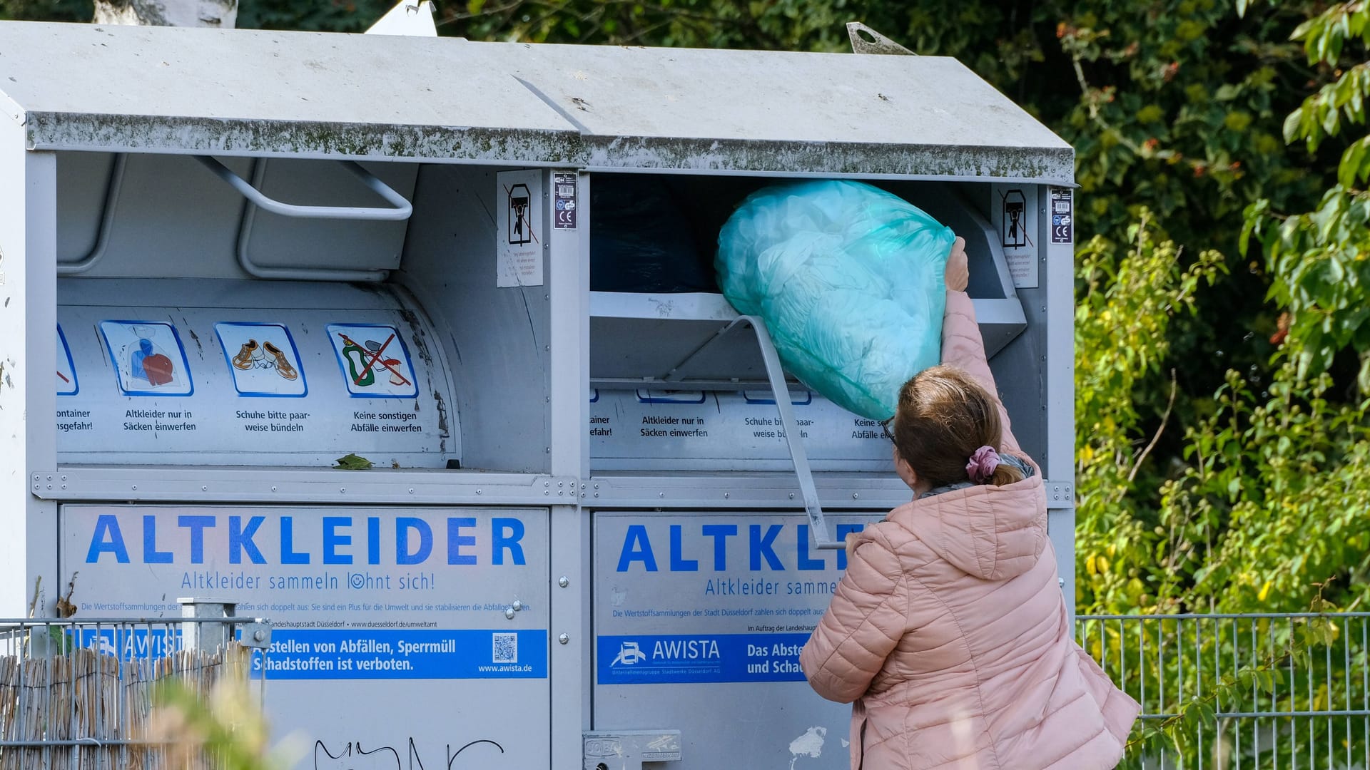 Person wirft Sack in Altkleidercontainer (Symbolbild): Die BSR informiert über die neue Recycling-Regelung.