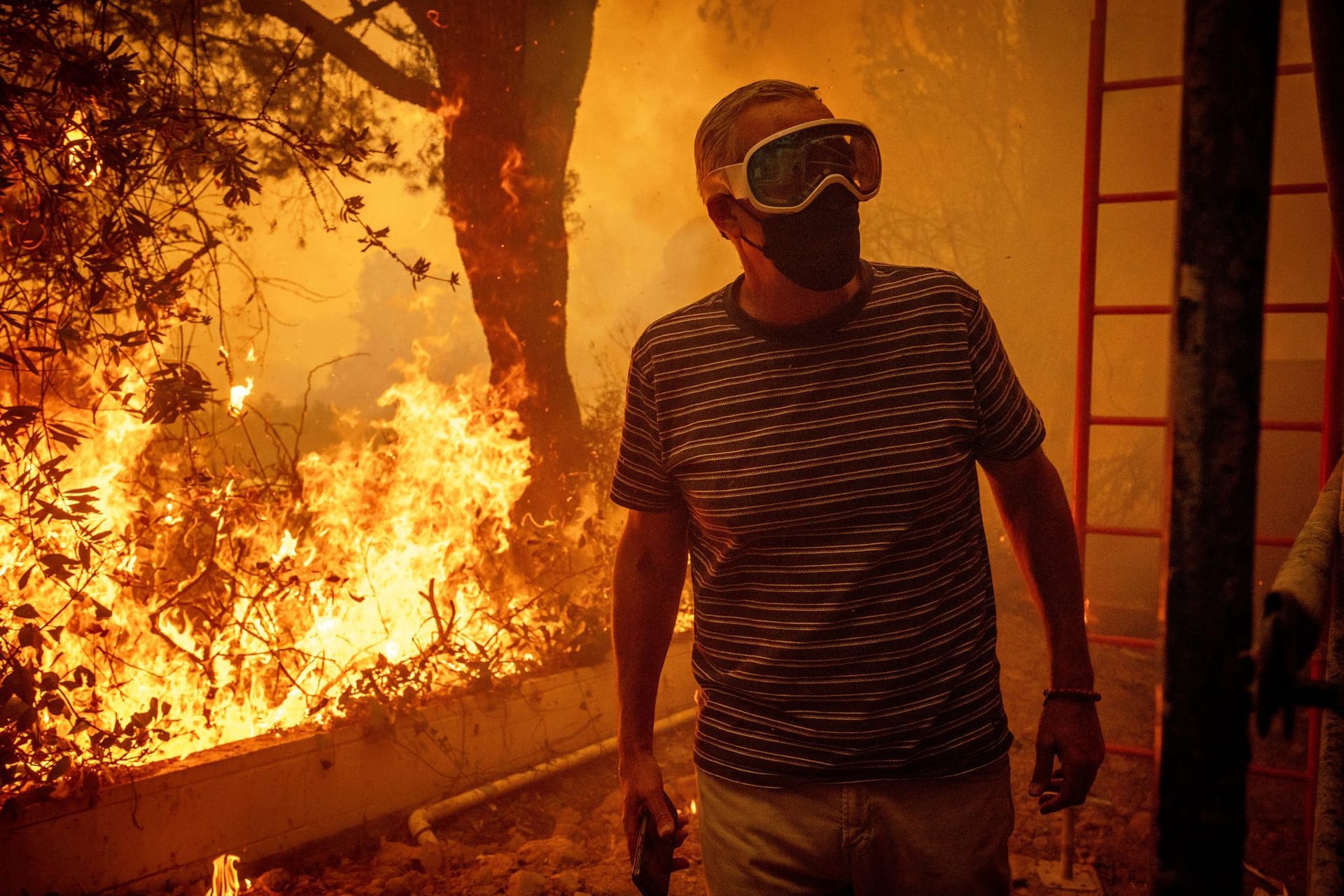 Will Adams beobachtet, wie sich die Flammen des Palisades-Feuers seinem Grundstück im Stadtteil Pacific Palisades von Los Angeles nähern.