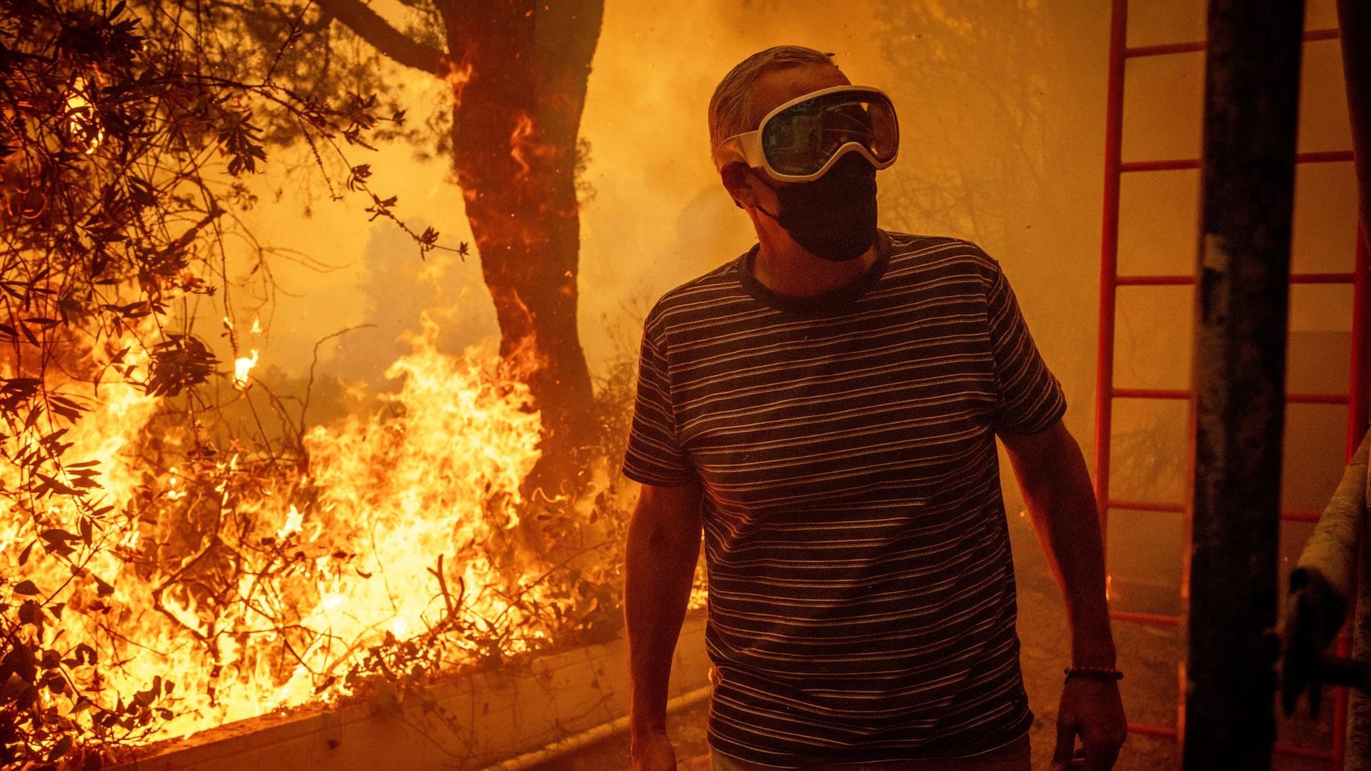 Will Adams beobachtet, wie sich die Flammen des Palisades-Feuers seinem Grundstück im Stadtteil Pacific Palisades von Los Angeles nähern.