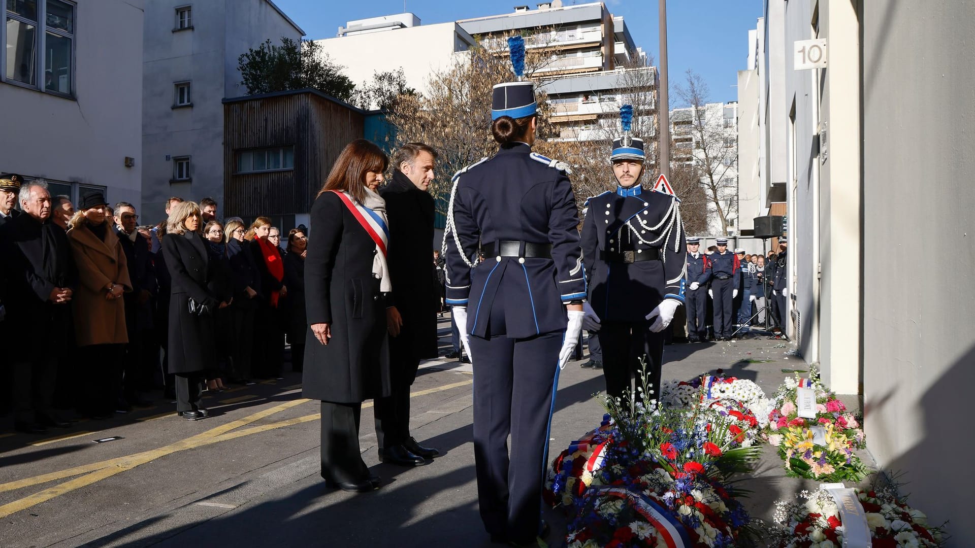 Der französische Staatspräsident Emmanuel Macron und die Pariser Bürgermeisterin Anne Hidalgo, Mitte links, bei der Gedenkfeier vor dem ehemaligen Sitz von "Charlie Hebdo".