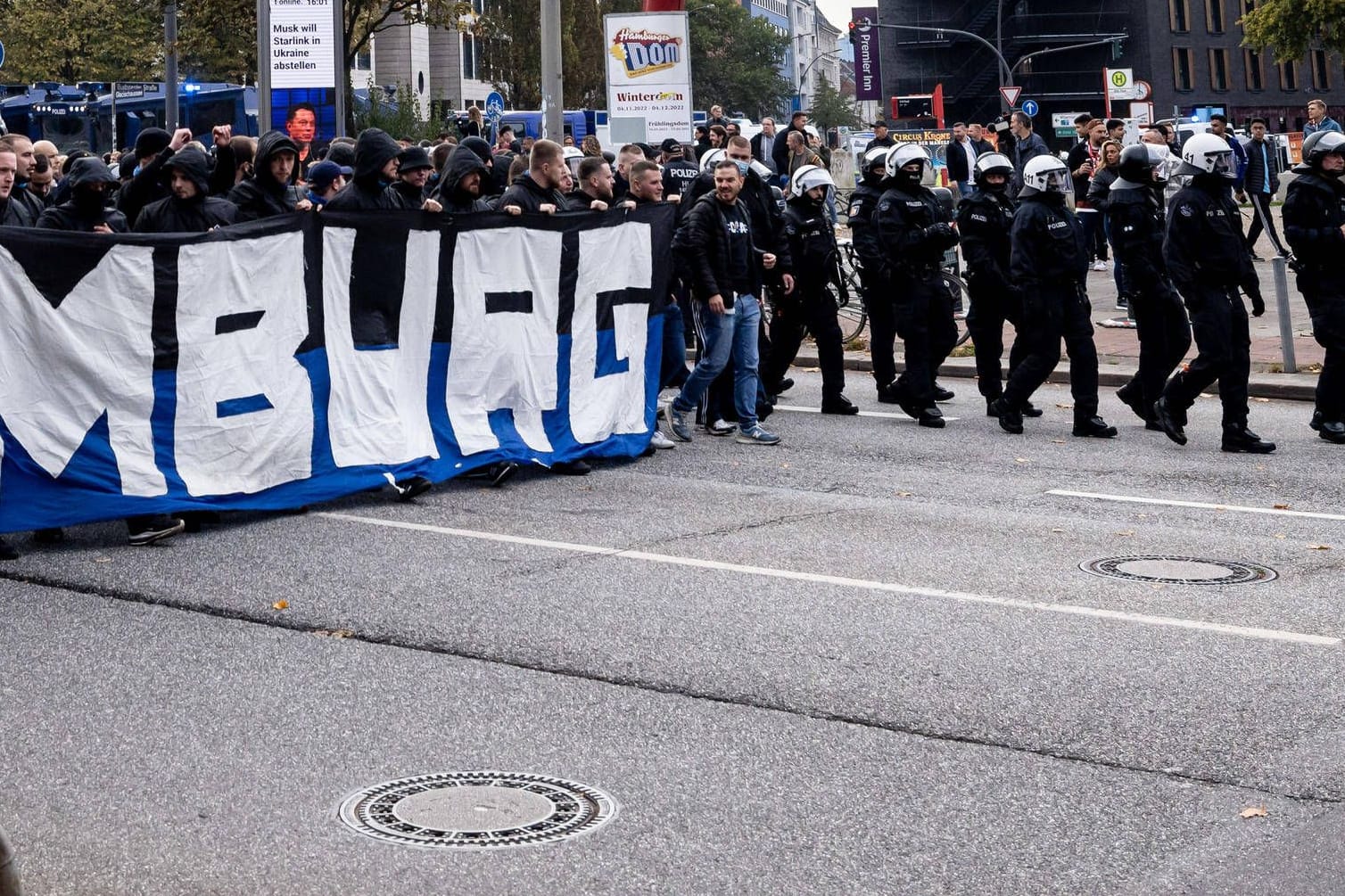 HSV-Fans marschieren unter Polizei-Aufsicht der Polizei ins Millerntor-Stadion (Archivbild): Solche Einsätze müssen bald die Klubs bezahlen.