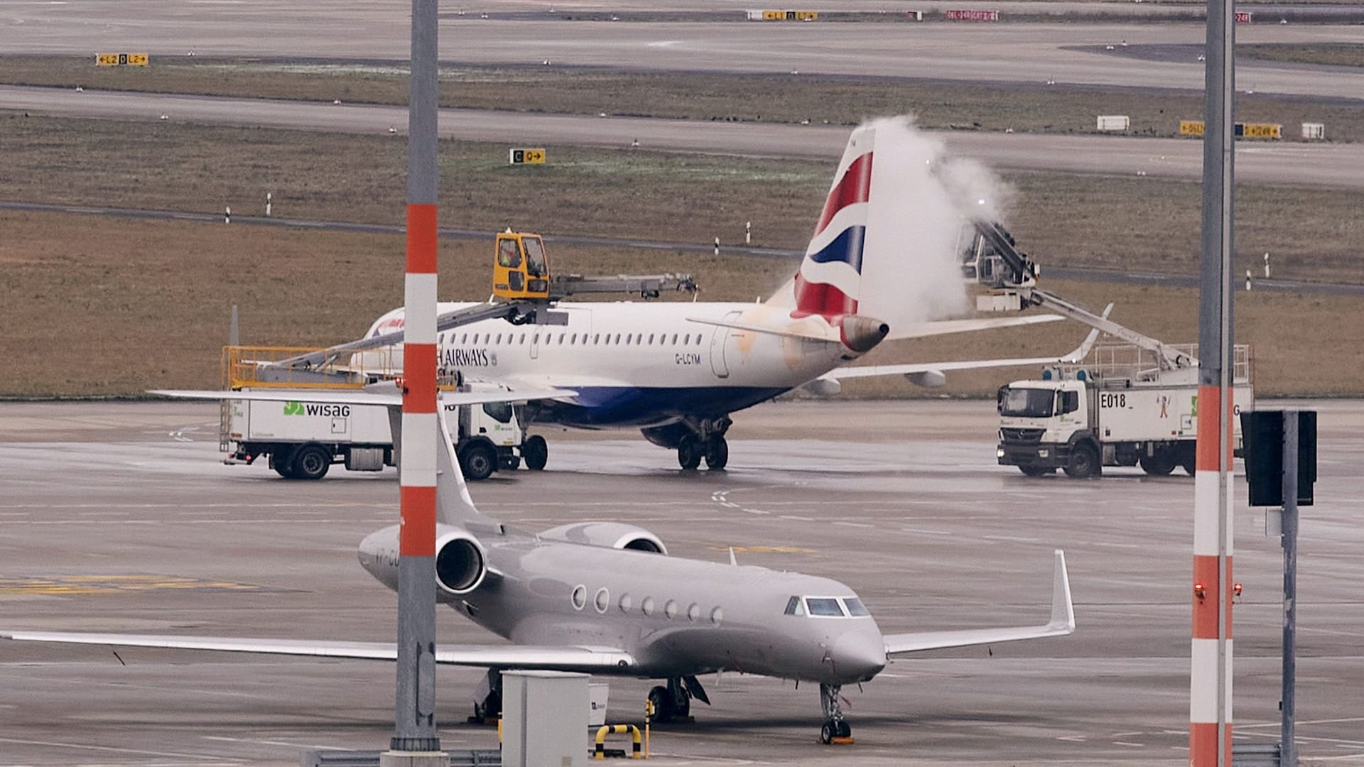 Ein Flugzeug der British Airways wird am BER von Eis befreit: Nicht nur am Hauptstadt-Flughafen kommt es zu Problemen.