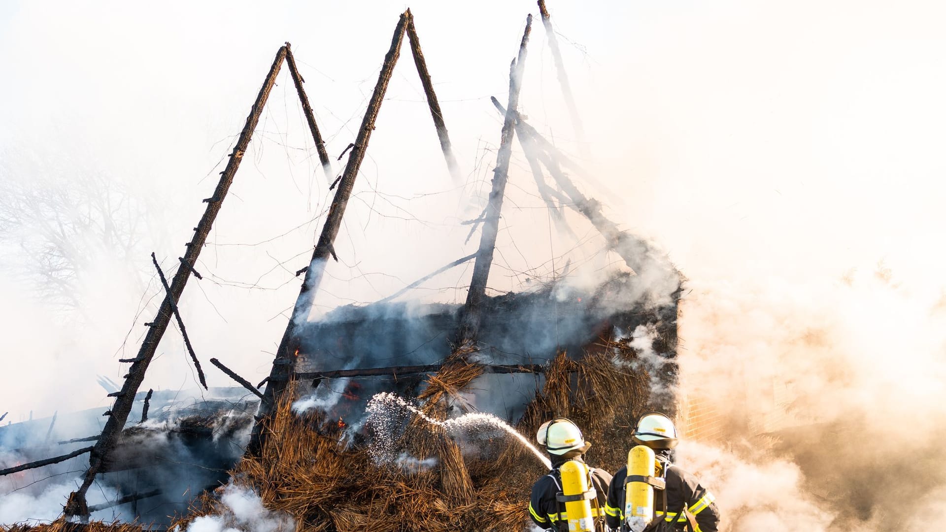 Einsatzkräfte löschen den Brand: Ein Reetdachhaus fing in Hamburg-Kirchwerder Feuer.