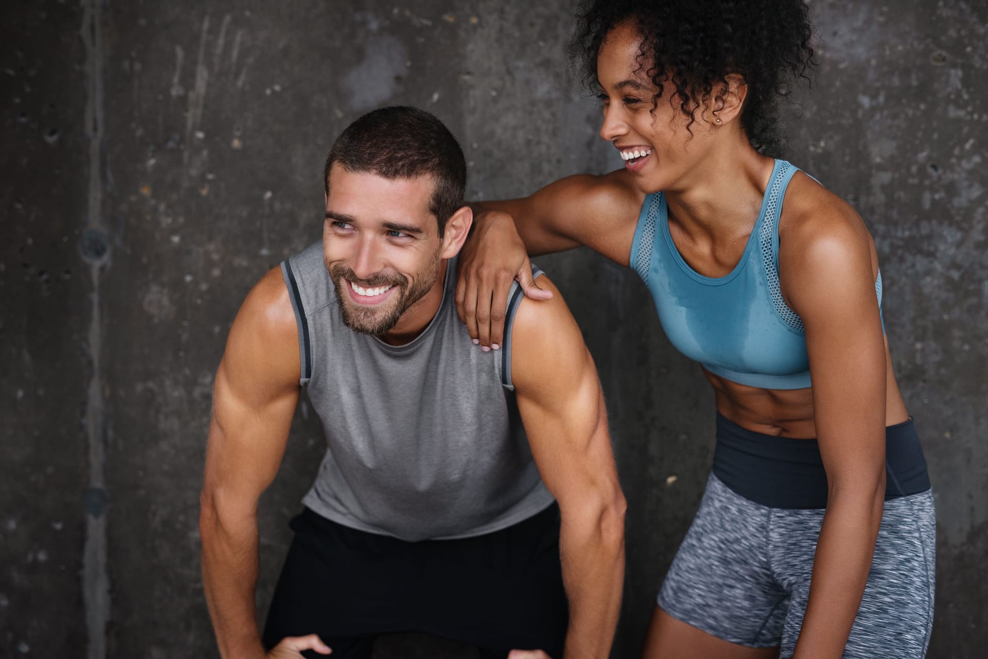 Ein Mann und eine Frau in Sportkleidung lachen.