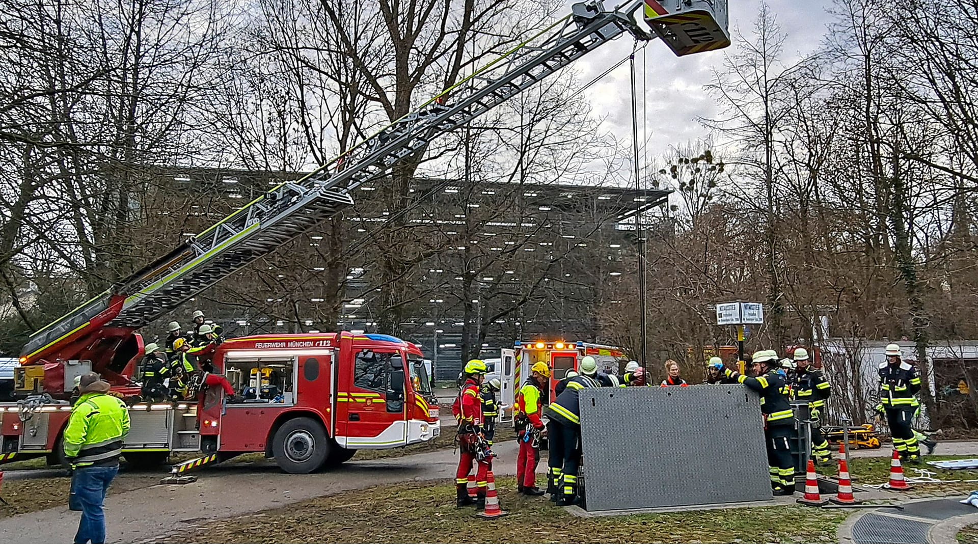 Mit einem Flaschenzug lassen Feuerwehrleute eine Trage zu einem Arbeiter ab, der in einen Schacht gefallen war.