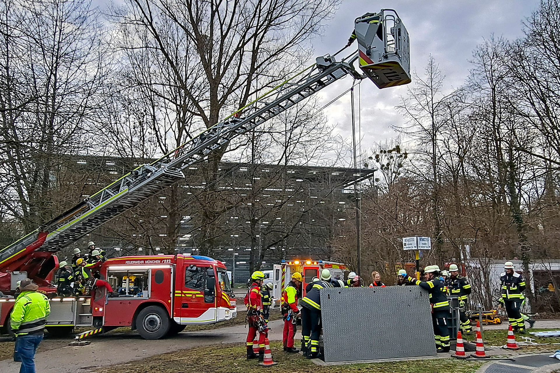 Mit einem Flaschenzug lassen Feuerwehrleute eine Trage zu einem Arbeiter ab, der in einen Schacht gefallen war.