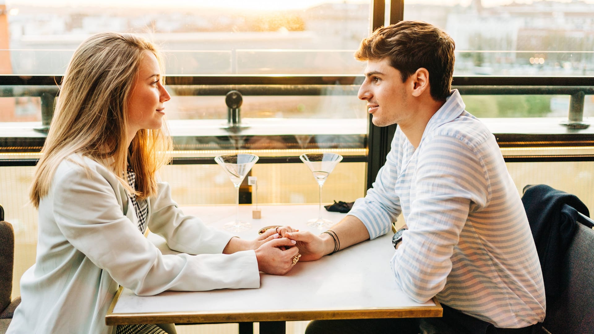 Ein junges Paar sitzt im Restaurant (Symbolbild): Unterschiedliche politische Ansichten führen beim Dating häufig zu Streit – wenn es zum Thema wird.