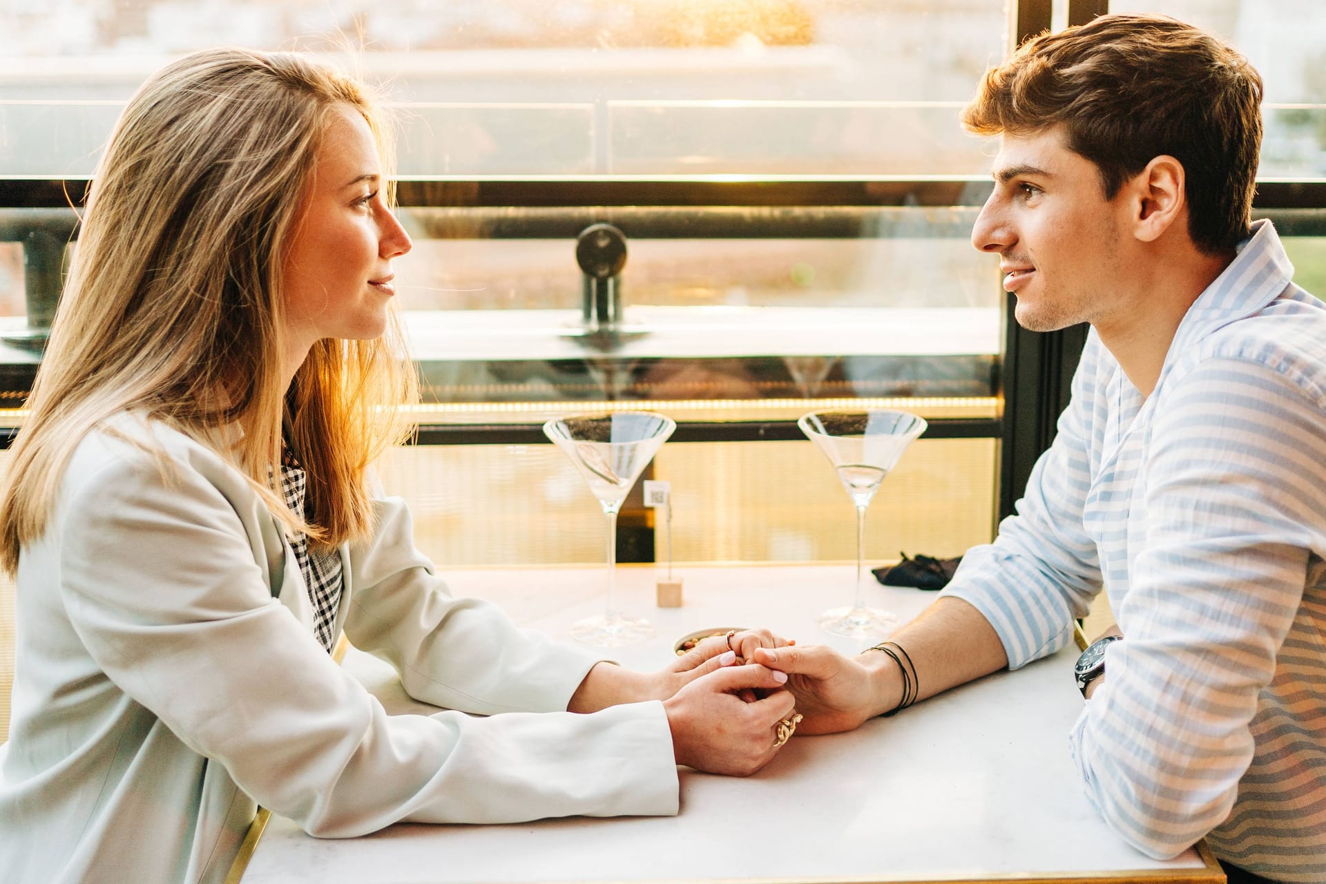 Ein junges Paar sitzt im Restaurant (Symbolbild): Unterschiedliche politische Ansichten führen beim Dating häufig zu Streit – wenn es zum Thema wird.