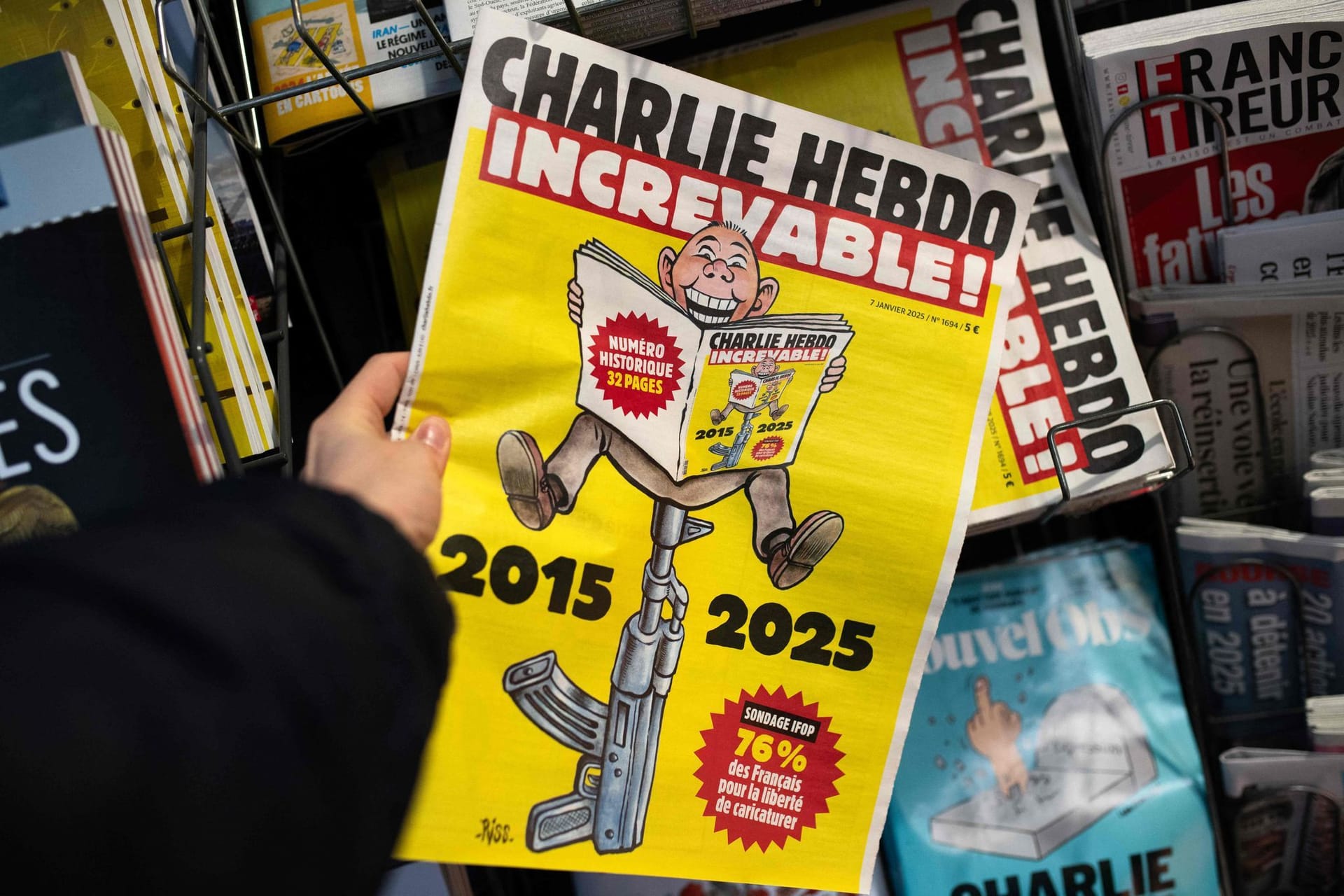 Eine Person hält eine Sonderausgabe der französischen Satirezeitung "Charlie Hebdo" vor dem 10. Jahrestag des Charlie Hebdo-Anschlags an einem Presseverkaufsstand in Paris.