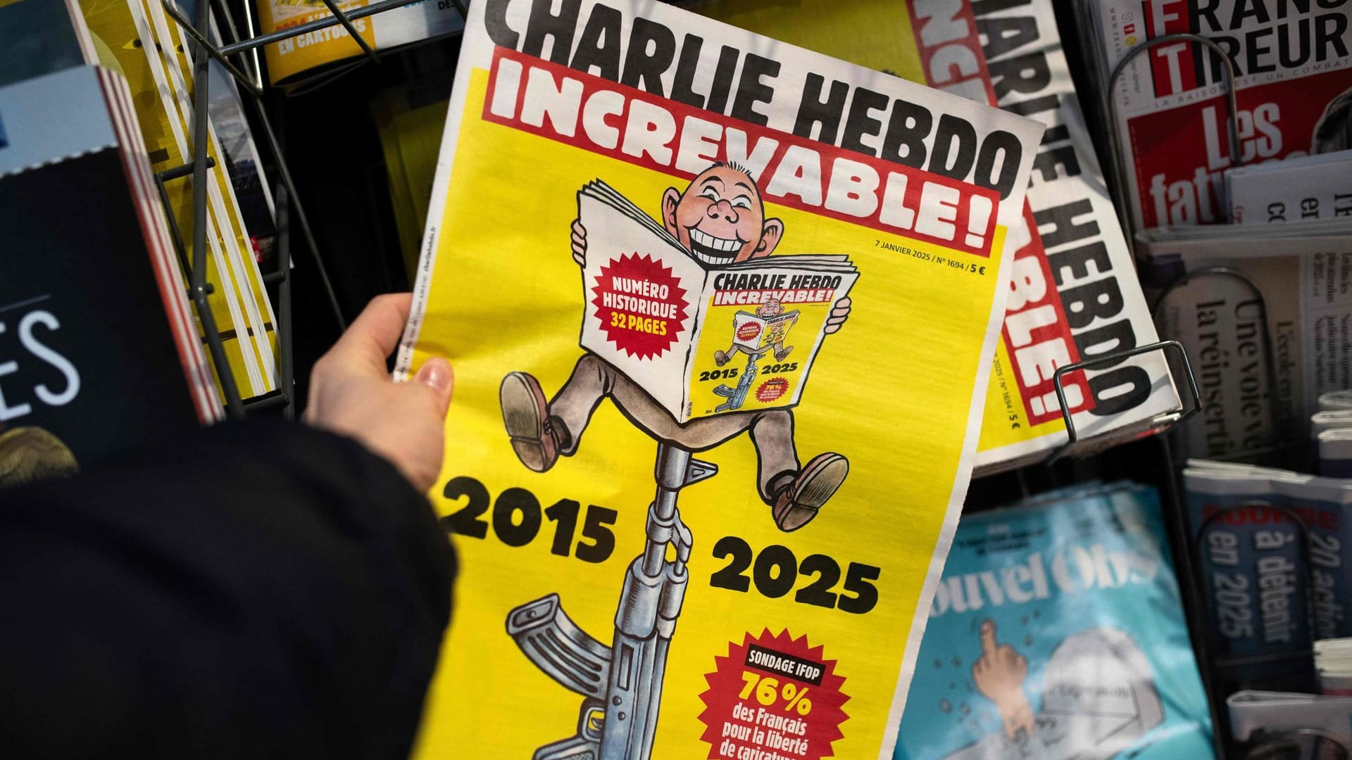 Eine Person hält eine Sonderausgabe der französischen Satirezeitung "Charlie Hebdo" vor dem 10. Jahrestag des Charlie Hebdo-Anschlags an einem Presseverkaufsstand in Paris.