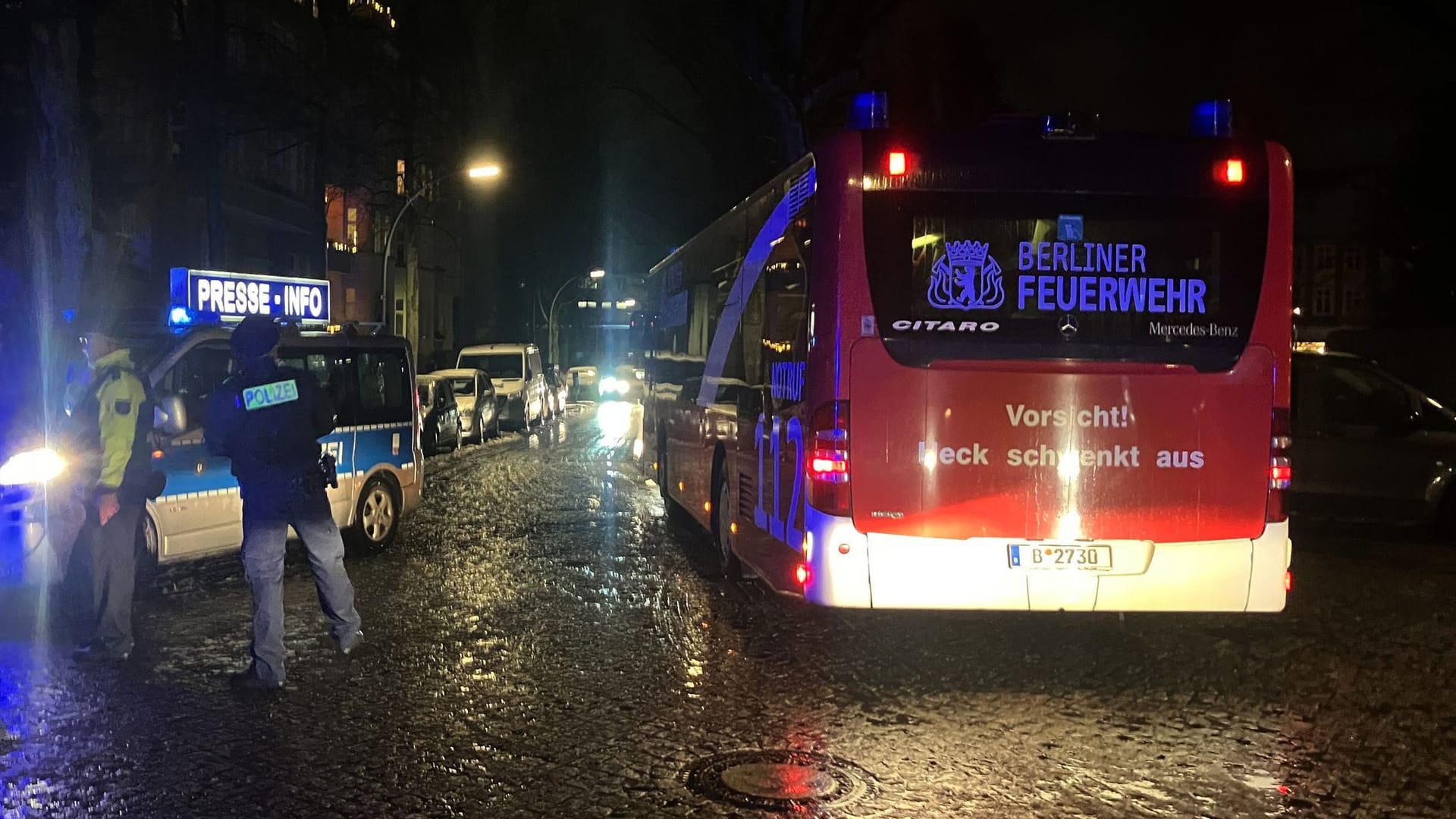 Ein Polizeifahrzeug und ein Kältebus stehen in der Nähe der Grundschule: Die Einsatzkräfte haben Entwarnung gegeben.