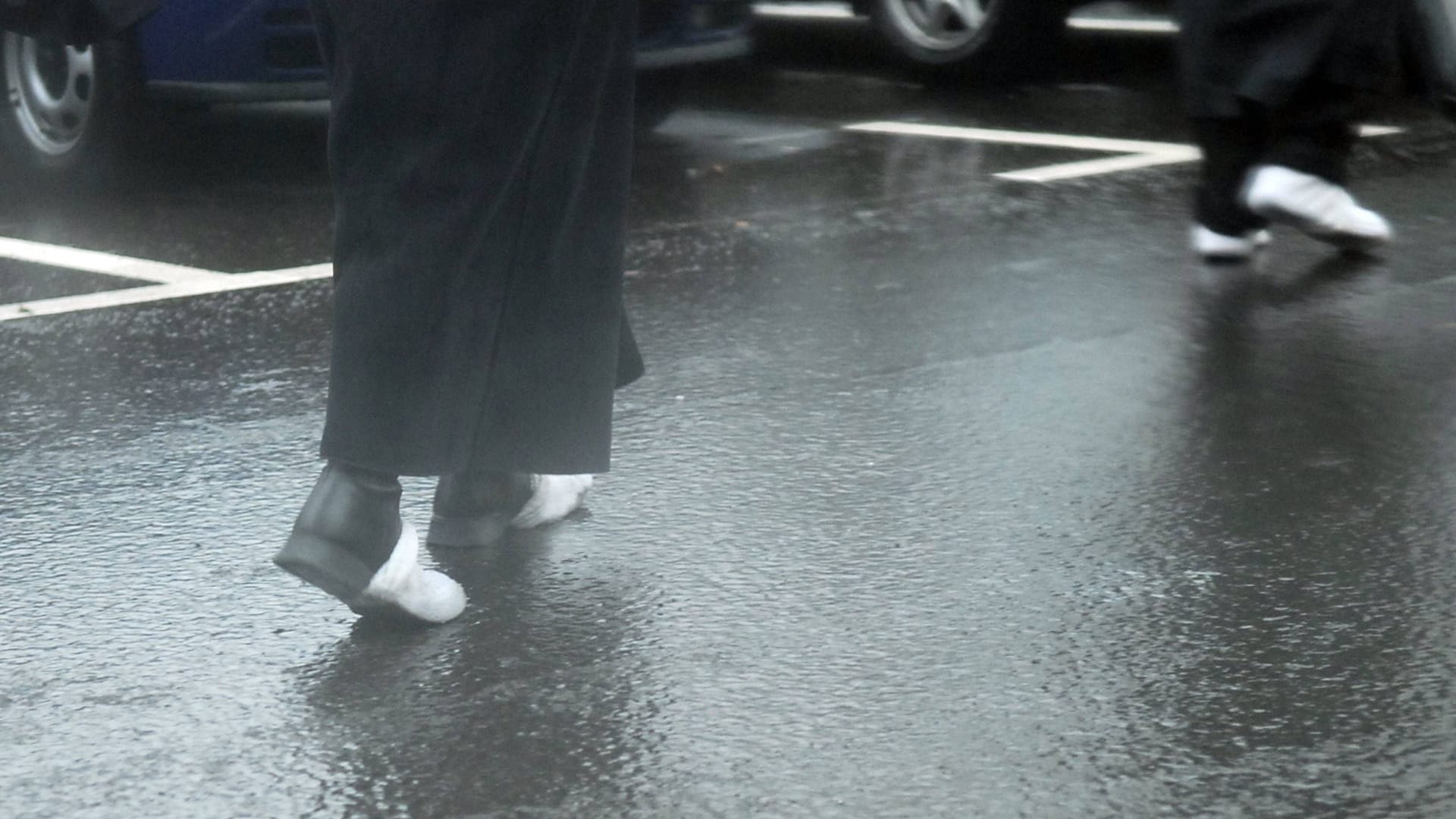 Fußgänger auf einer glatten Straße: Bevor es in Berlin und Brandenburg milder wird, ist es zunächst weiter kalt.