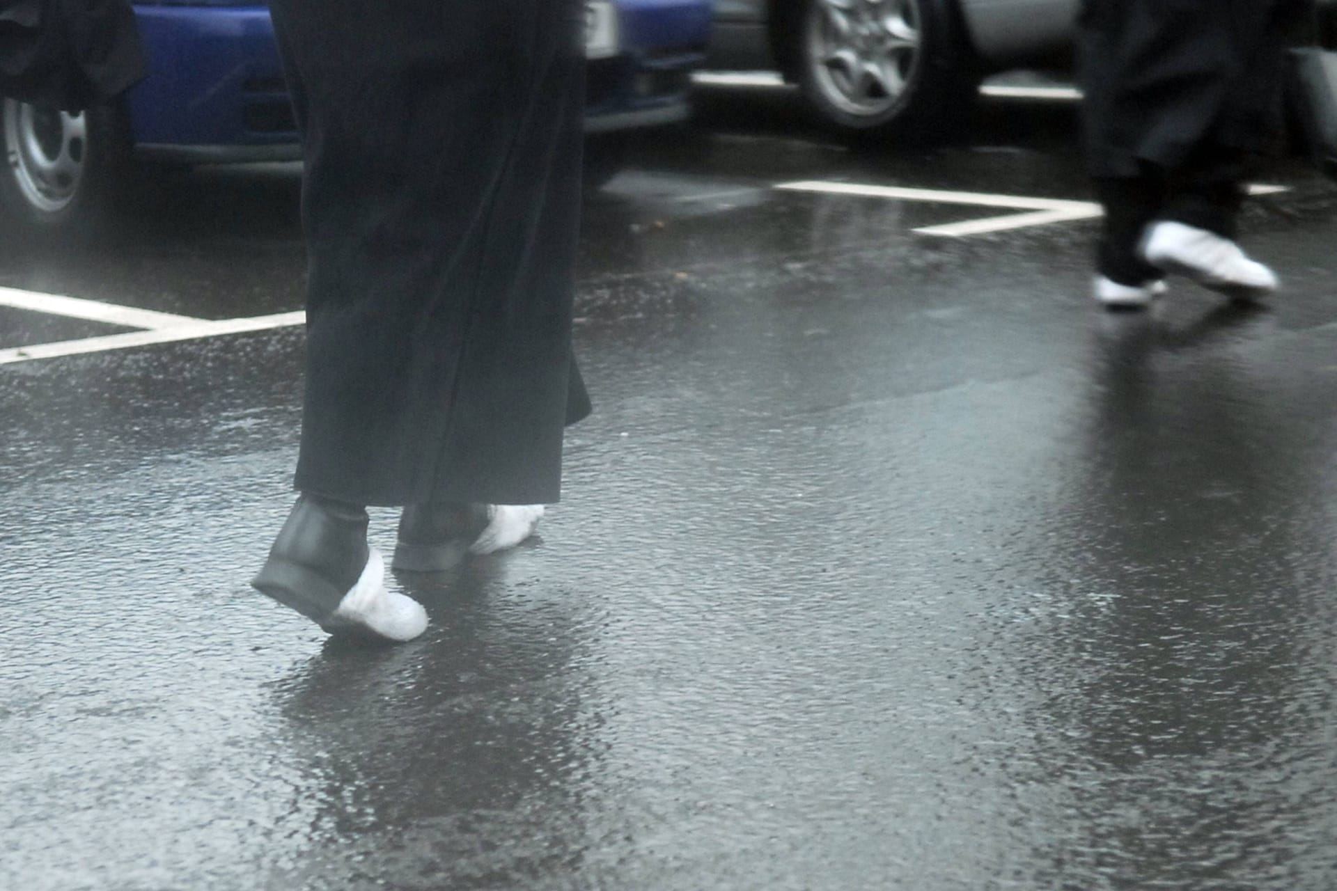 Fußgänger auf einer glatten Straße: Bevor es in Berlin und Brandenburg milder wird, ist es zunächst weiter kalt.