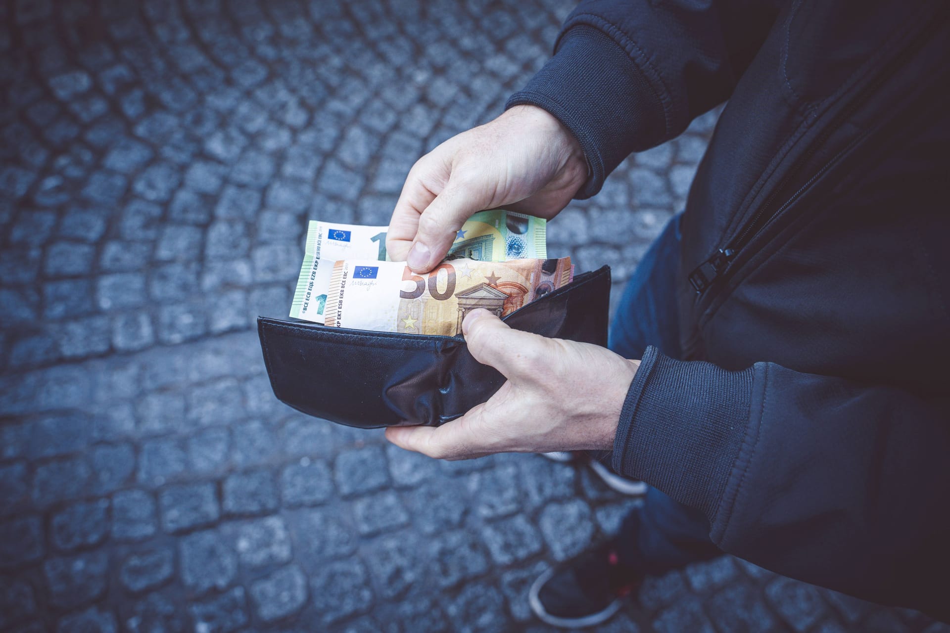 Ein Mann zieht Bargeld aus einem Geldbeutel (Archivbild): Die Kriminalpolizei hat die Ermittlungen aufgenommen.