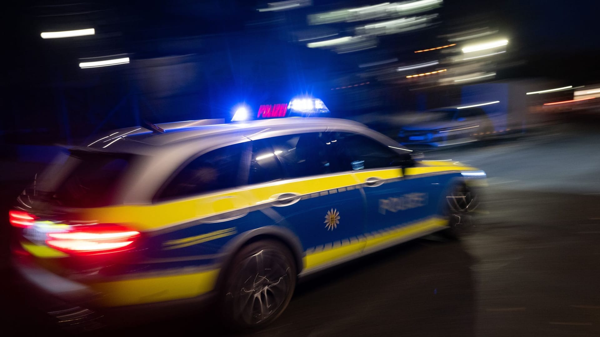 Ein Polizeiauto fährt mit Blaulicht zum Einsatz. (Symbolbild)