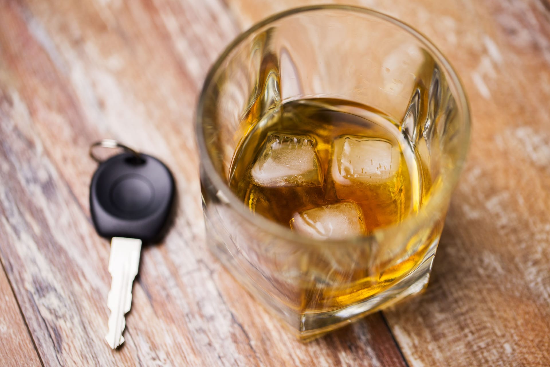 close up of alcohol and car key on table