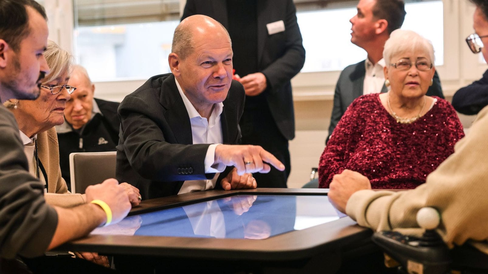 Scholz im Marie-Juchacz-Zentrum mit Bewohnern an einem digitalen Spieltisch.