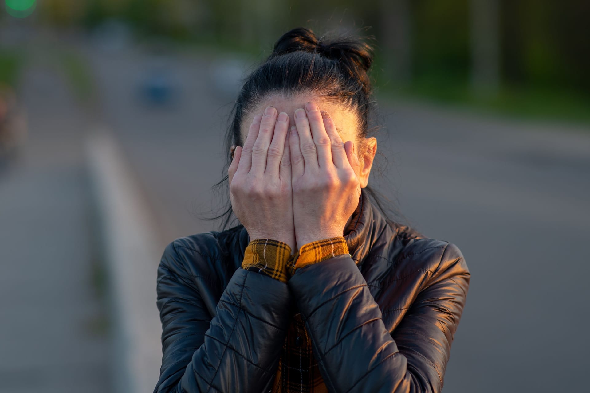 soft focus, woman covers face with palms. shame, sadness, joy. female hands affected by a fungal disease. simple gray background, medicine, sick nails, necrosis