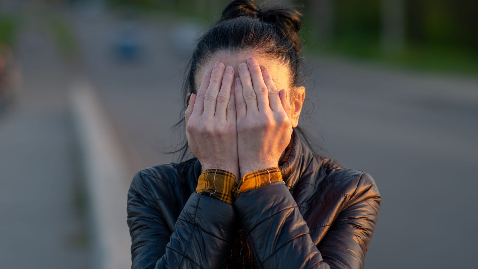 soft focus, woman covers face with palms. shame, sadness, joy. female hands affected by a fungal disease. simple gray background, medicine, sick nails, necrosis