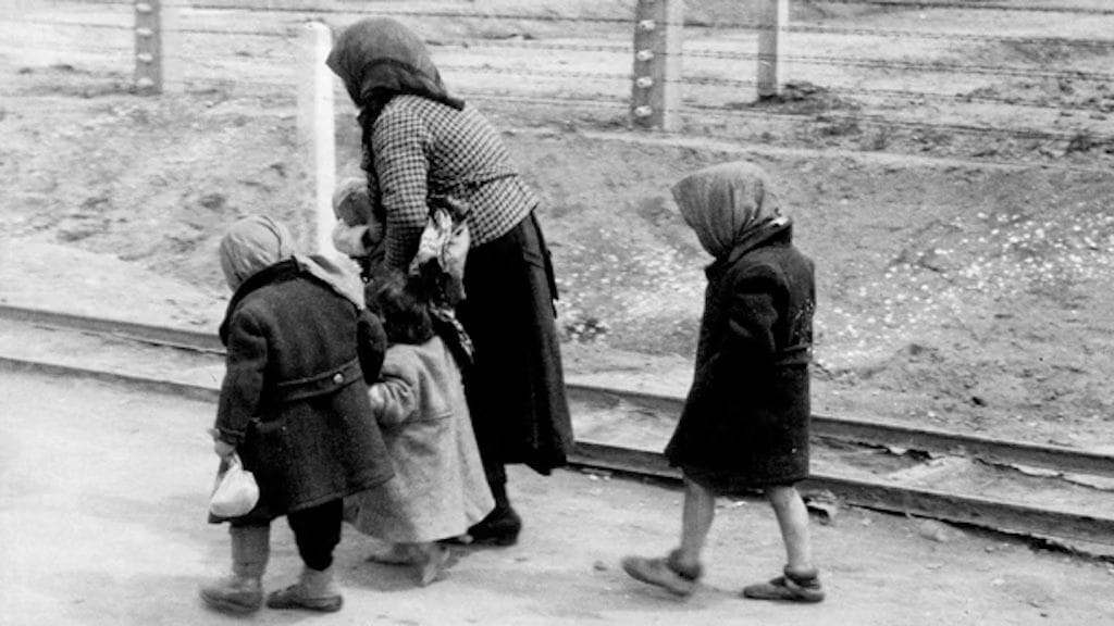 Eine alte Frau geht mit Kindern die letzten Schritte zur Gaskammer. Das Bild entstand kurz vor ihrem Tod.