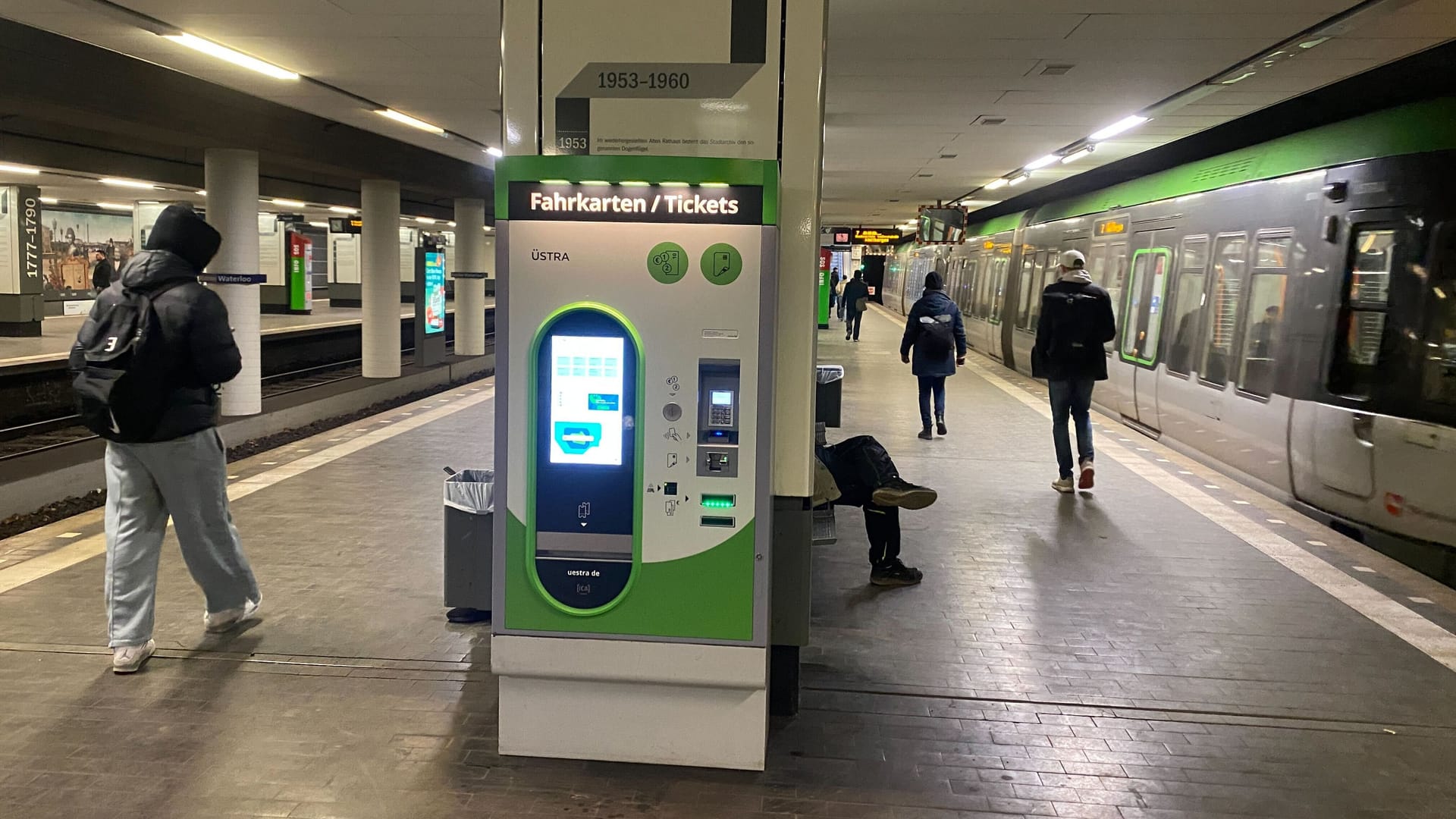 Der Fahrkartenautomat verdeckt weiterhin einen Großteil des an der Säule dahinter angebrachten Zeitstrahls.