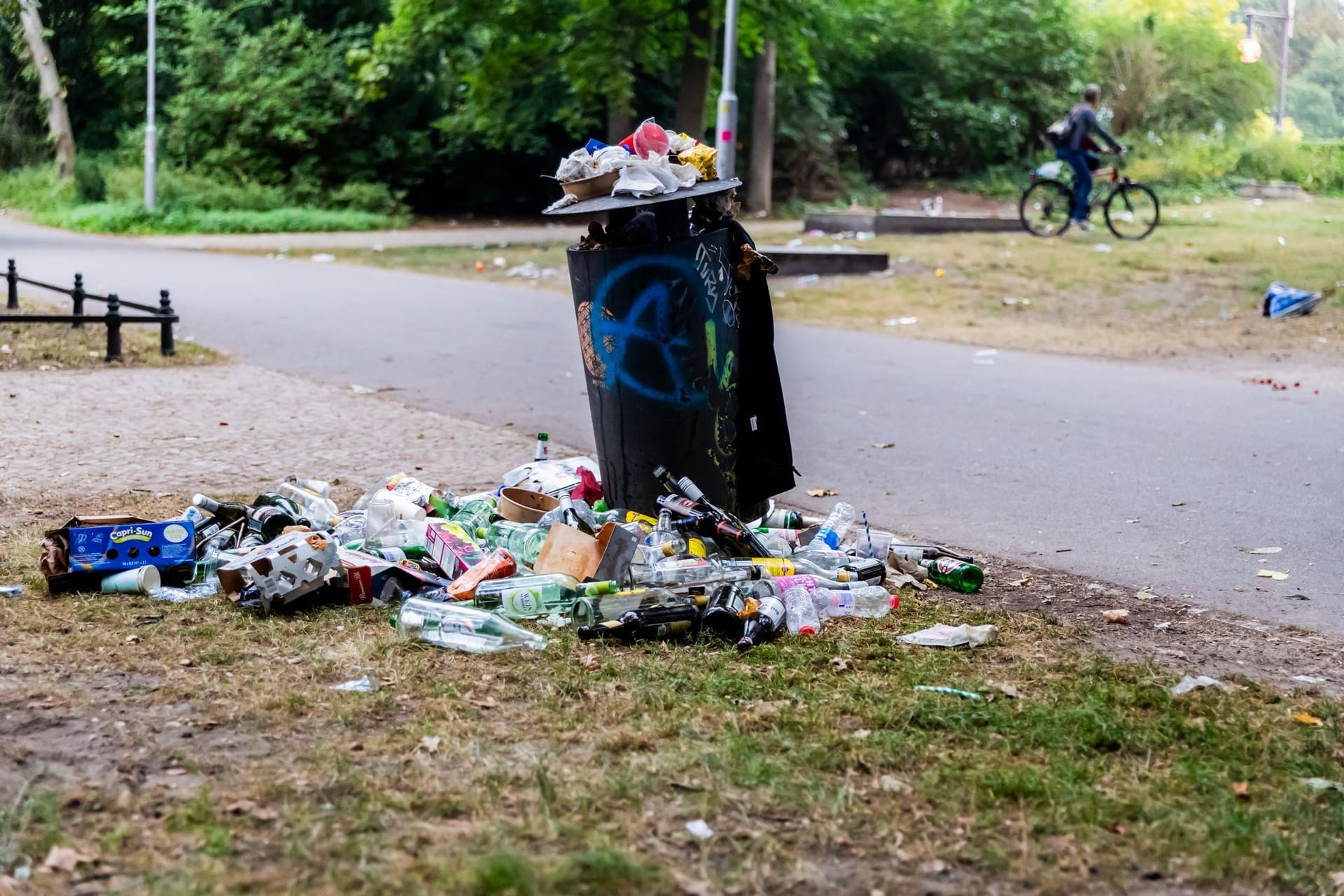 ARCHIV - 18.08.2024, Berlin: Ein Mülleimer im Tiergarten quillt am frühen Morgen nach der Technoparade «Rave the Plantet» über. (zu dpa: «Nach Urteil: Kommt in Berlin die Verpackungssteuer?»)