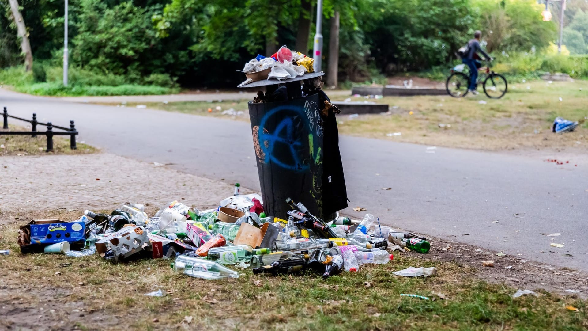 ARCHIV - 18.08.2024, Berlin: Ein Mülleimer im Tiergarten quillt am frühen Morgen nach der Technoparade «Rave the Plantet» über. (zu dpa: «Nach Urteil: Kommt in Berlin die Verpackungssteuer?»)