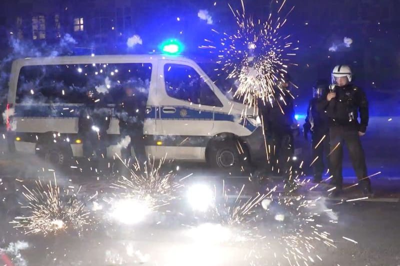 Polizeibeamte stehen am Silvesterabend hinter explodierendem Feuerwerk. Vergangenes Silvester kam es vor allem in Berlin zu Ausschreitungen: Junge Männer randalierten mit Böllern und Raketen, attackierten Einsatzkräfte. Nancy Faeser befürchtet eine Wiederholung.