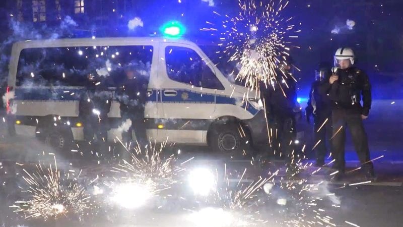 Polizeibeamte stehen am Silvesterabend hinter explodierendem Feuerwerk. Vergangenes Silvester kam es vor allem in Berlin zu Ausschreitungen: Junge Männer randalierten mit Böllern und Raketen, attackierten Einsatzkräfte. Nancy Faeser befürchtet eine Wiederholung.