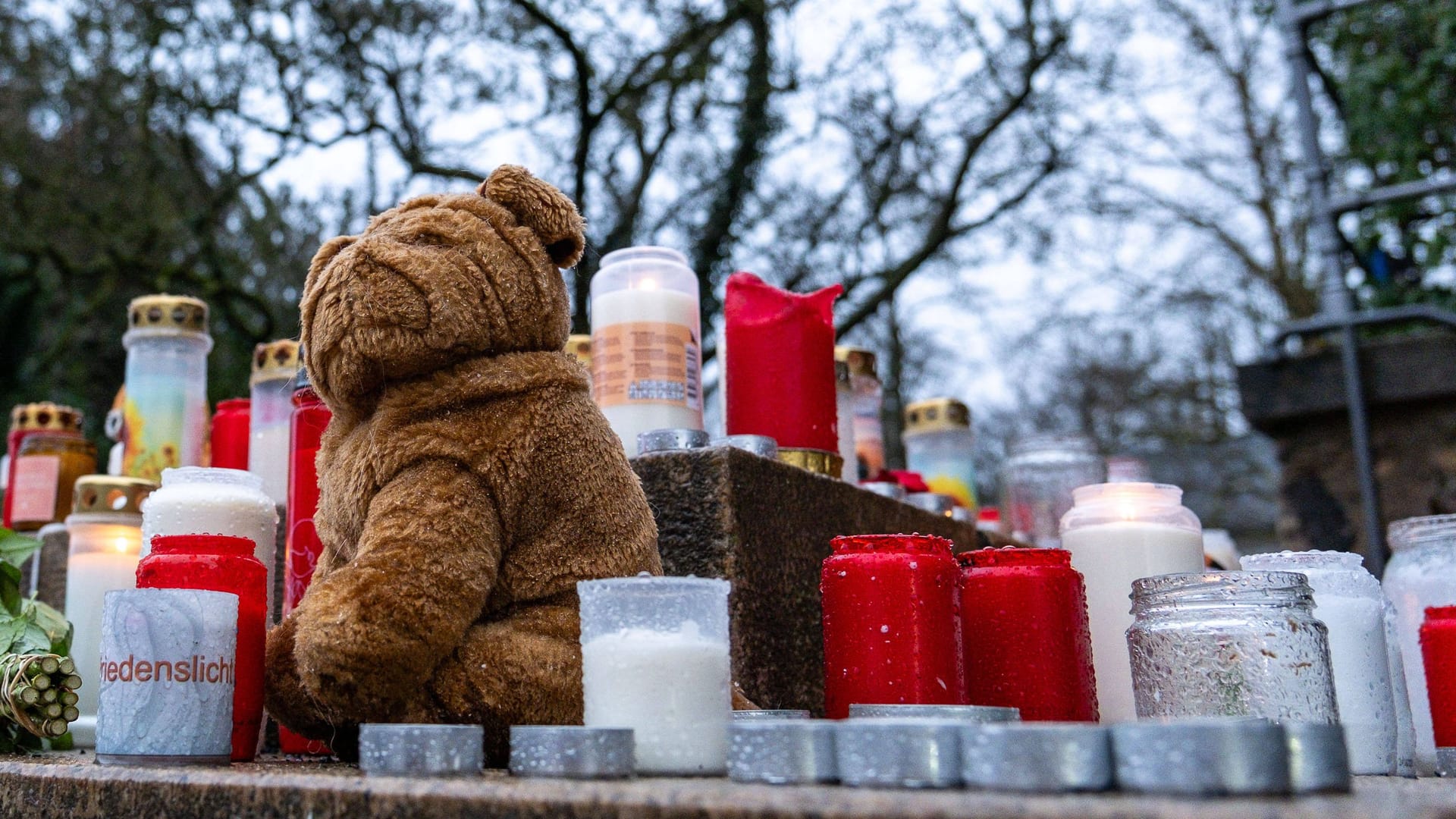 Trauerkerzen, Blumen und Kuscheltiere liegen am Eingang vom Park Schöntal in Aschaffenburg.