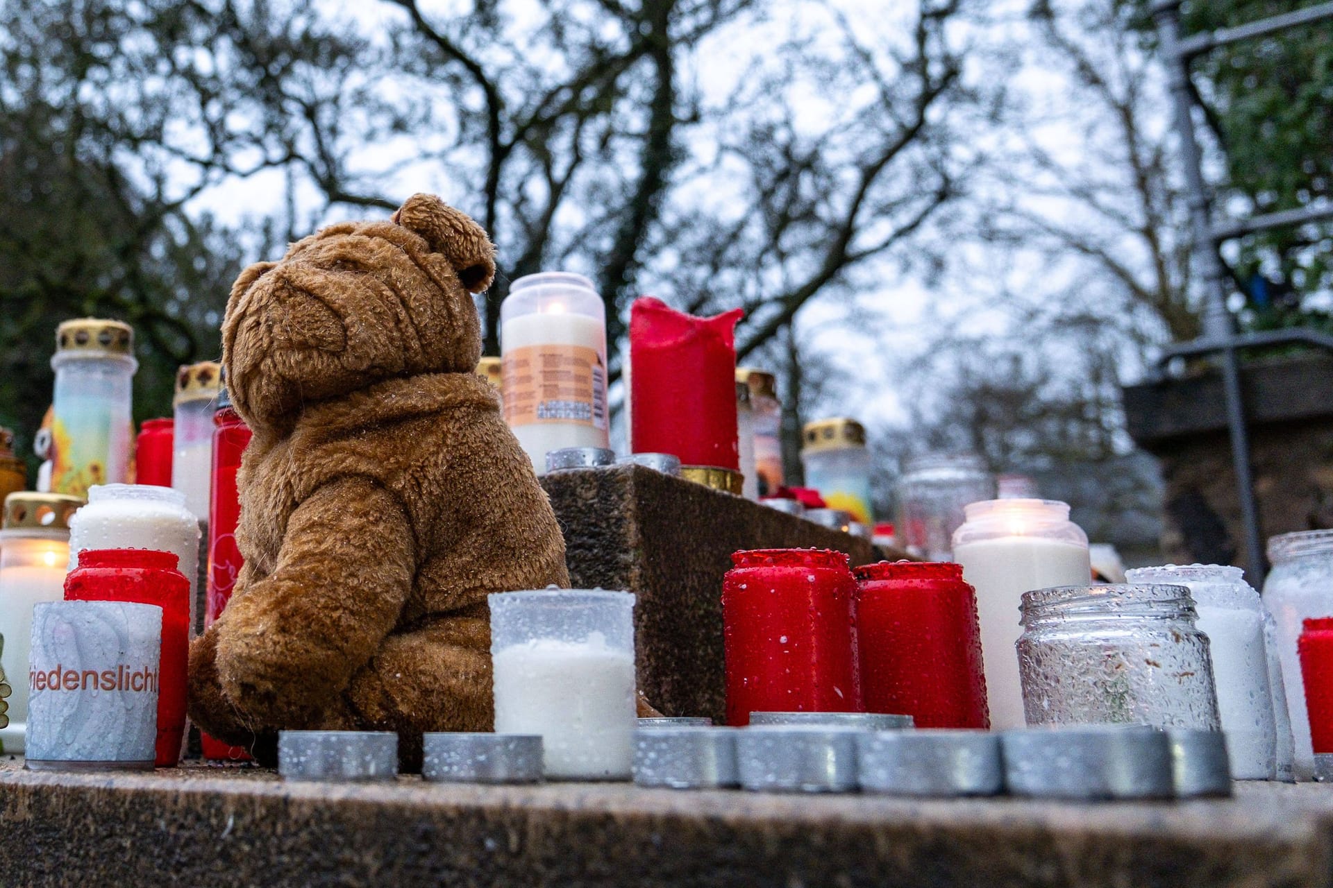 Trauerkerzen, Blumen und Kuscheltiere liegen am Eingang vom Park Schöntal in Aschaffenburg.