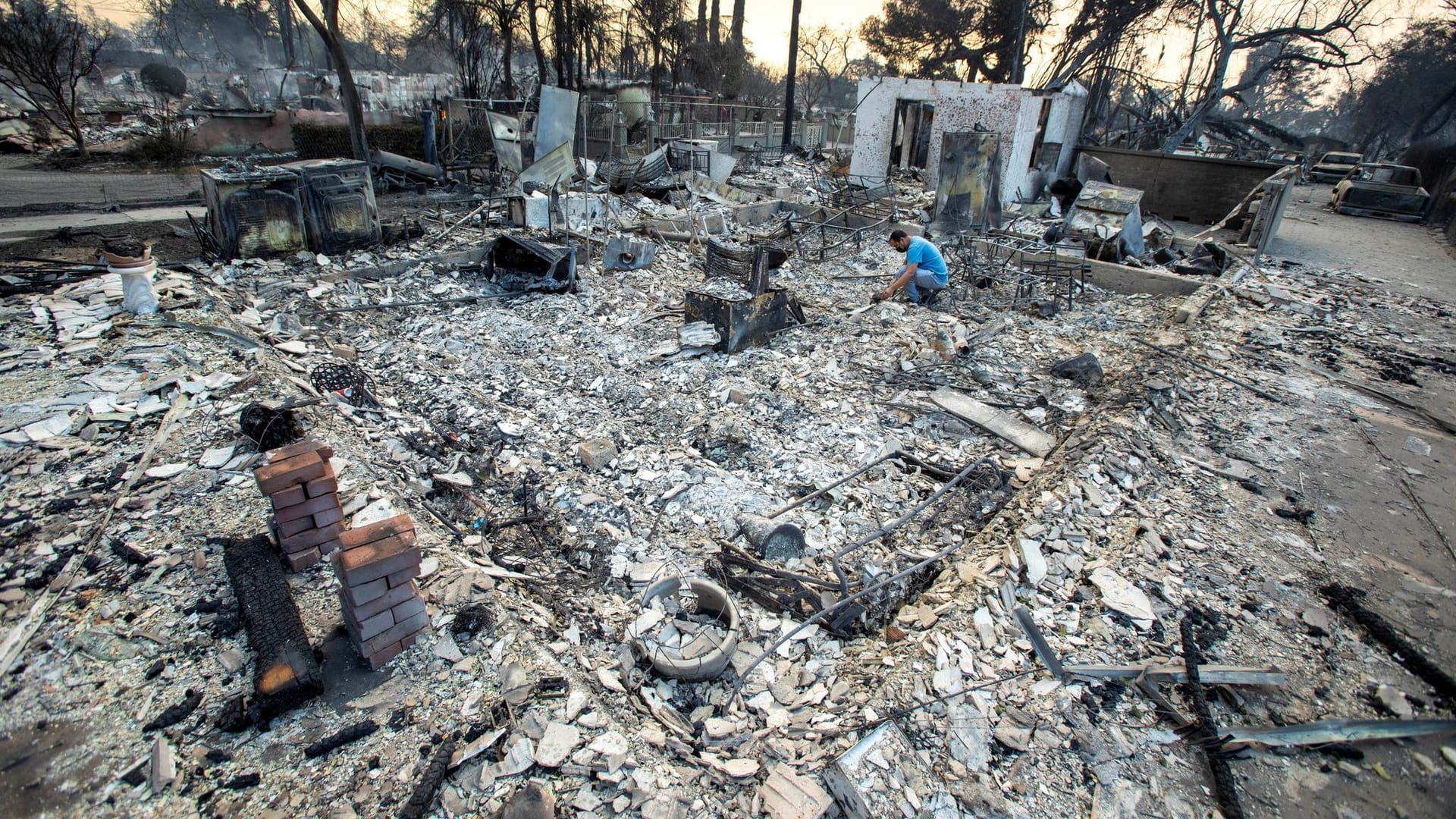 Ein Mann sucht nach Überbleibseln: Ein so großes Feuer hat Los Angeles noch nicht gesehen.