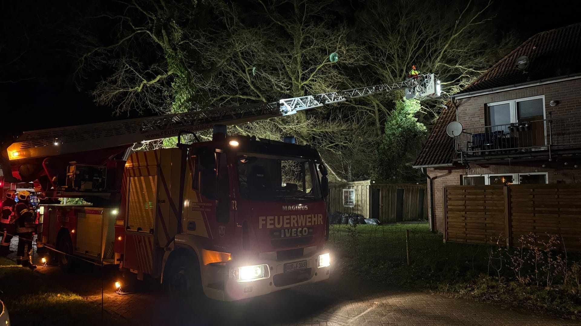 Einsatzkräfte der Feuerwehr sichern in Aurich einen umgestützen Baum.