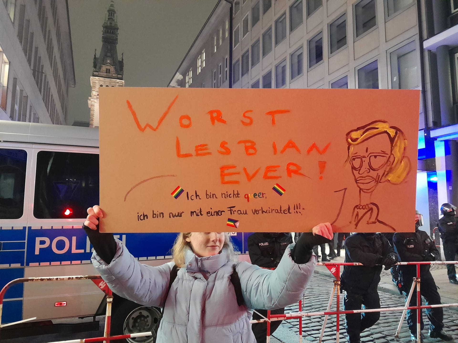 Eine Demonstrantin mit Plakat am Rande des Bannkreises vor dem Hamburger Rathaus