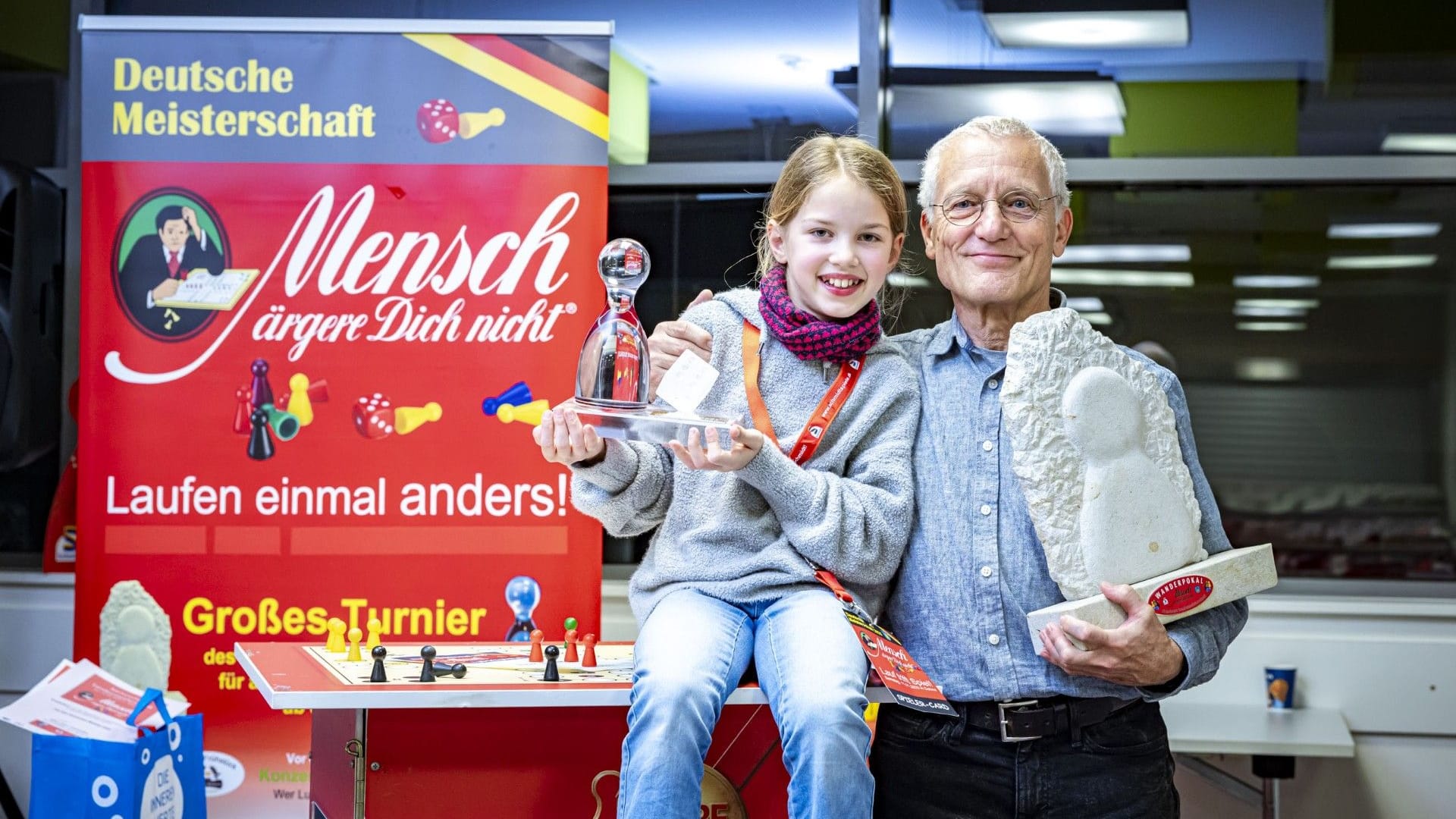 Sieger Peter Rentzsch (69), aus Dohna gewinnt erneut die Deutsche Meisterschaft im "Mensch ärgere dich nicht" in Dohna im Jahr 2025, unten: Mila Grimm (9, unten, links) aus Dresden, Platz 3, sie wurde die Deutsche Junioren-Meisterin,