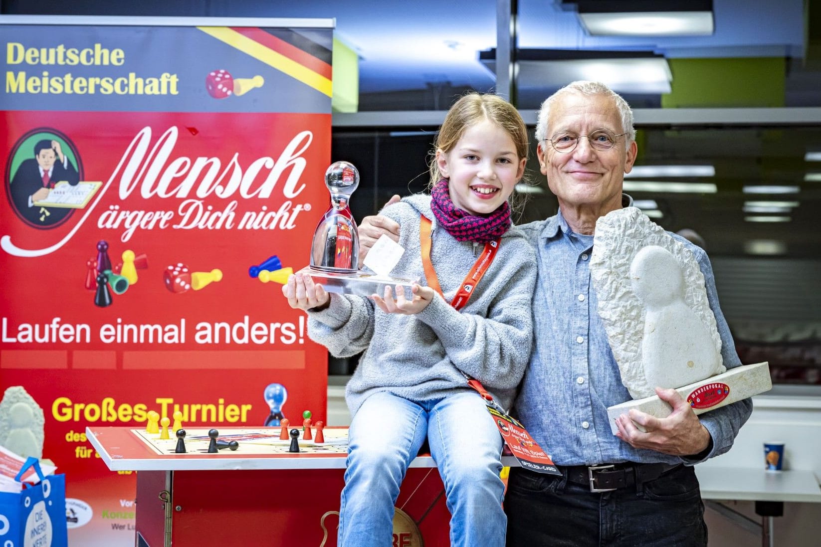 Sieger Peter Rentzsch (69), aus Dohna gewinnt erneut die Deutsche Meisterschaft im "Mensch ärgere dich nicht" in Dohna im Jahr 2025, unten: Mila Grimm (9, unten, links) aus Dresden, Platz 3, sie wurde die Deutsche Junioren-Meisterin,