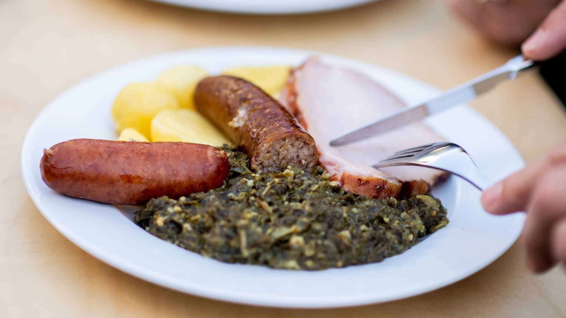 Zum Grünkohl gehören Salzkartoffeln, Kochwurst, Pinkelwurst und Kasseler.