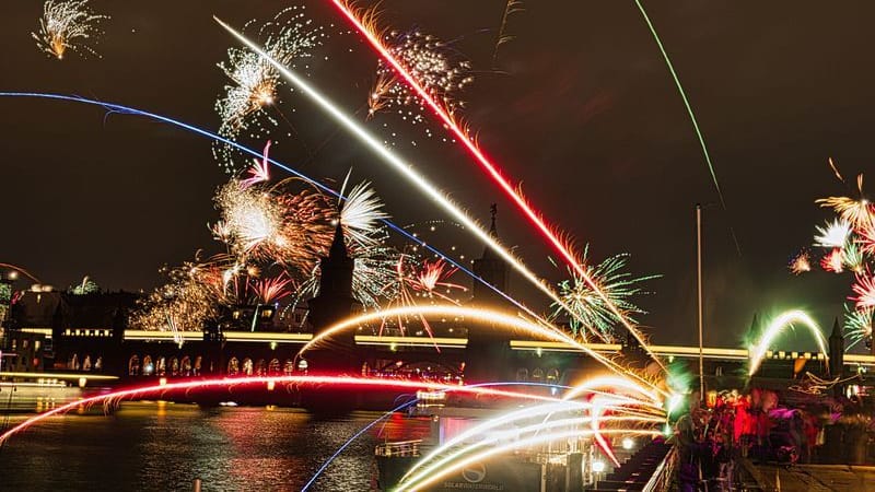 Feuerwerkskörper gehen an Silvester hinter der Oberbaumbrücke in den Nachthimmel hoch.